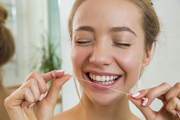woman flossing her teeth