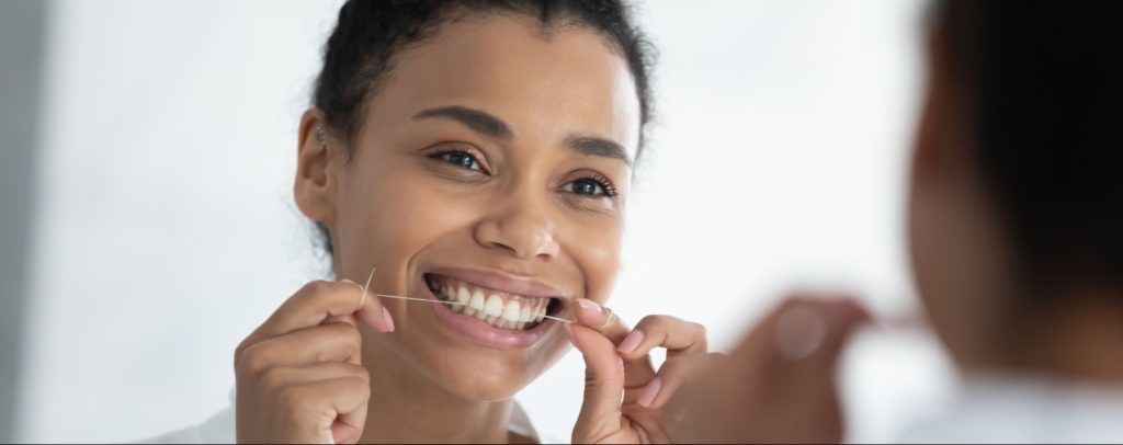 woman flossing her teeth