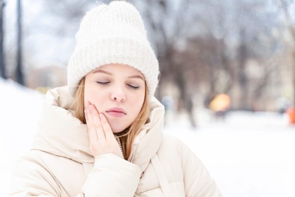 woman with tooth pain in the snow