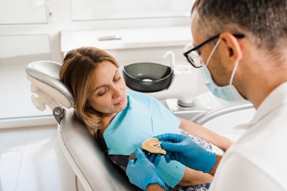 Periodontist discussing gum disease stages with a patient in a modern dental office